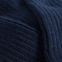 Nahaufnahme eines marineblauen Rippstrickstoffs, der Struktur und Falten zeigt, ideal für Rumpfs 1120 Stulpen mit Fersenloch.